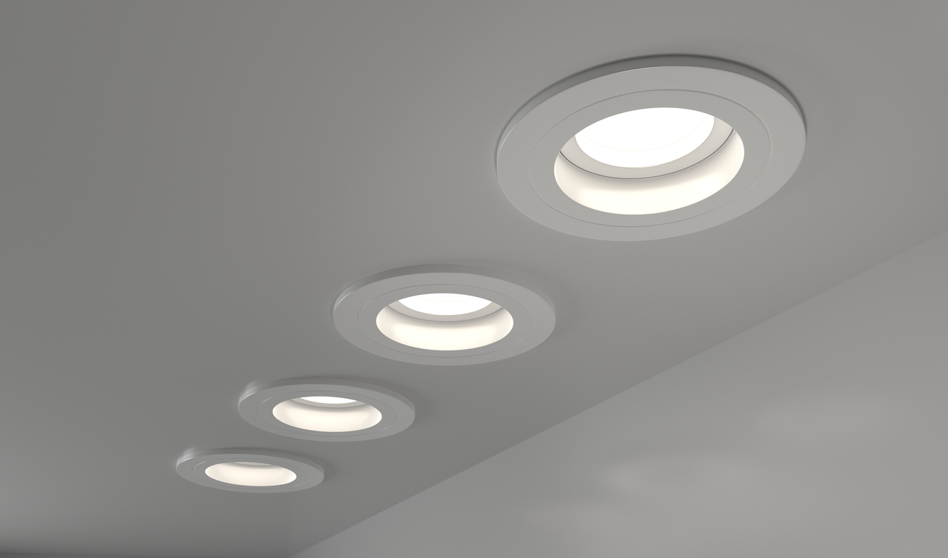 Four recessed ceiling lights illuminate a room with a modern design.