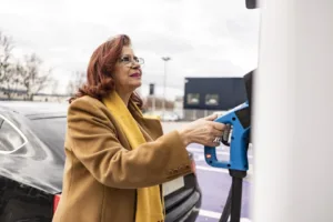 Woman using an EV charging station on a commercial property