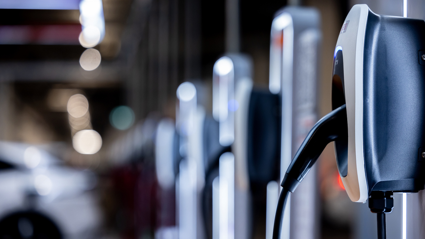 Electric car charging stations lined up in a parking area.