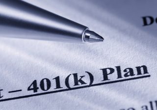 Close-up of a 401(k) plan document with a pen pointing at the text.